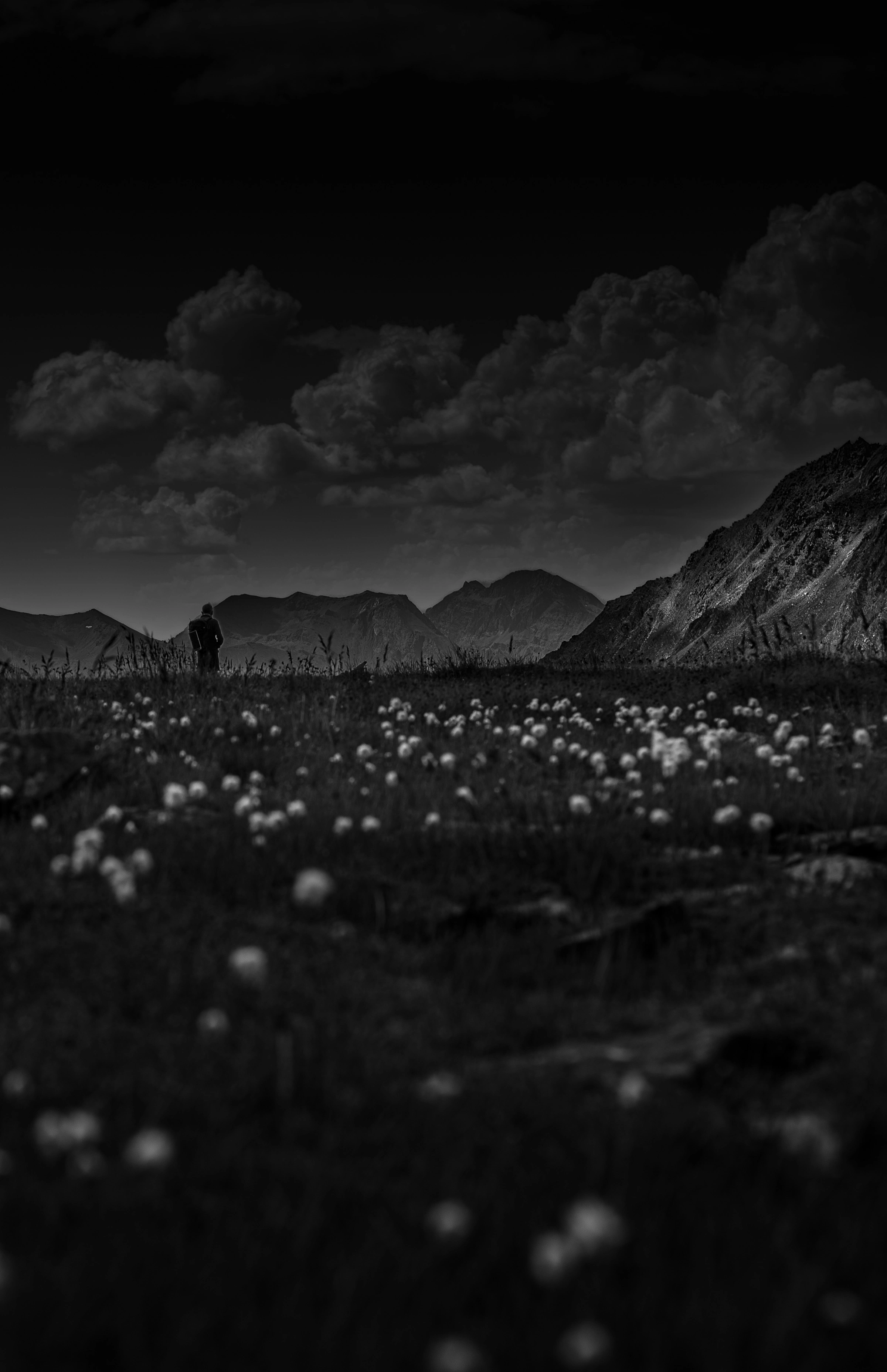 Photographie de montagne — personnage solitaire face aux sommets alpins, paysage dramatique